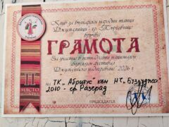 Танцьори във фолклорни носии изпълняват хоро на открита сцена